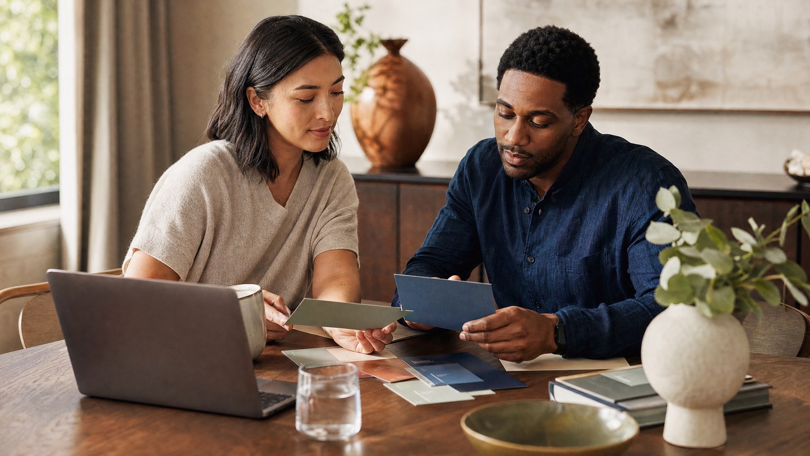 Fictional adults calmly comparing health-program options at a sunlit kitchen table; generated brand imagery, not real patients
